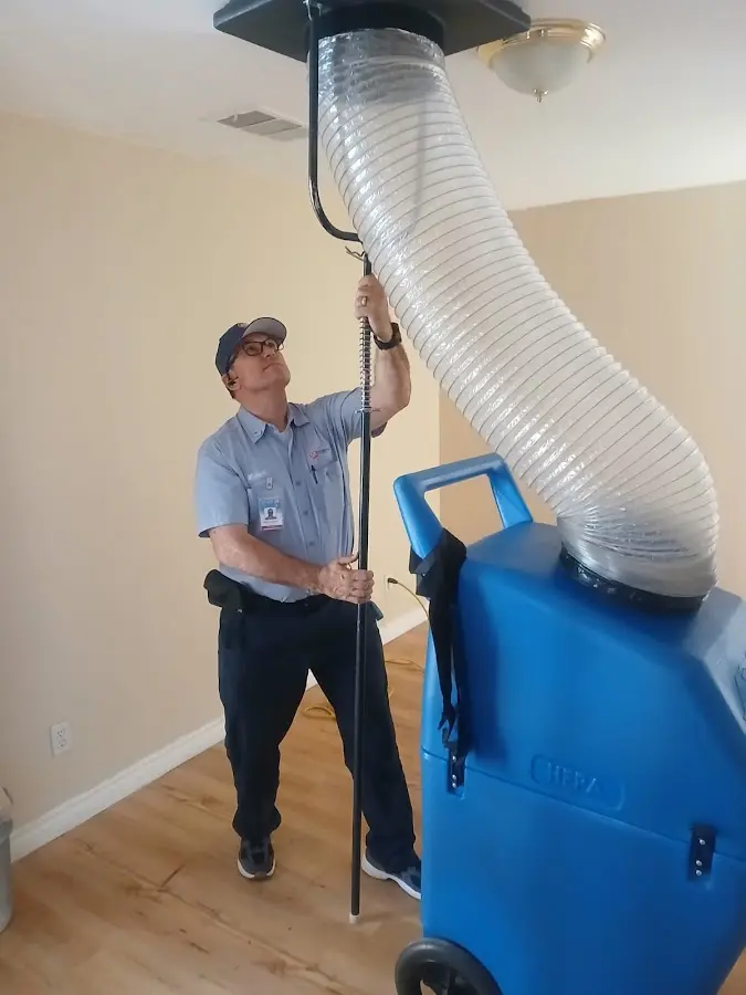 Furnace Tune-Up technician using HEPA equipment in Triana